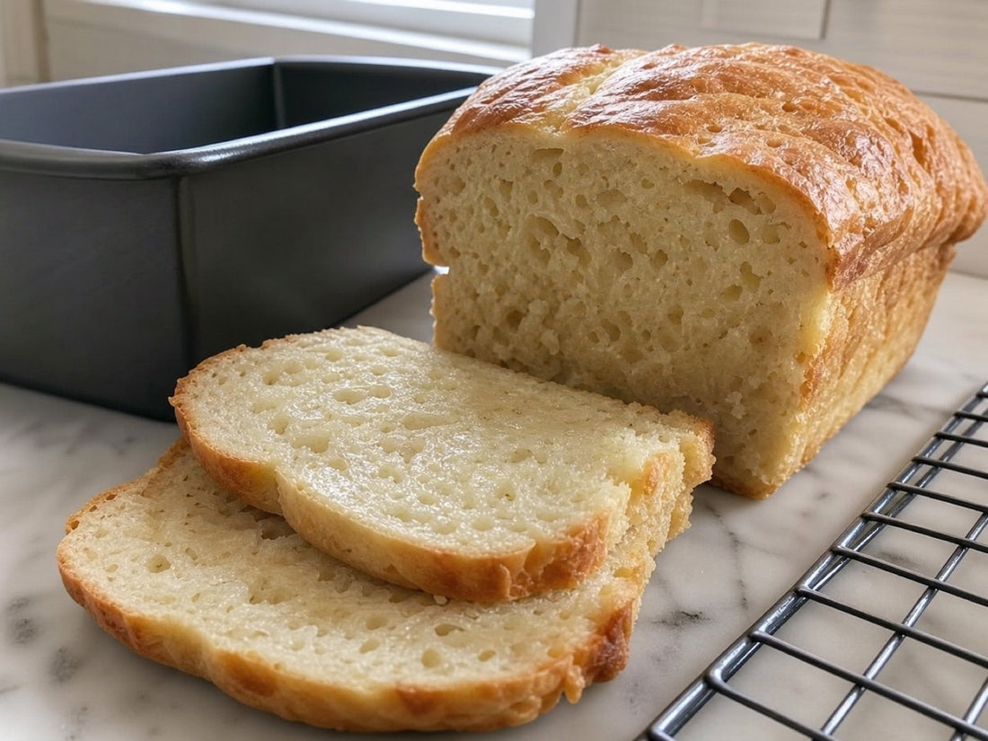 Sliced homemade bread with a moist gummy crumb beside a loaf pan
